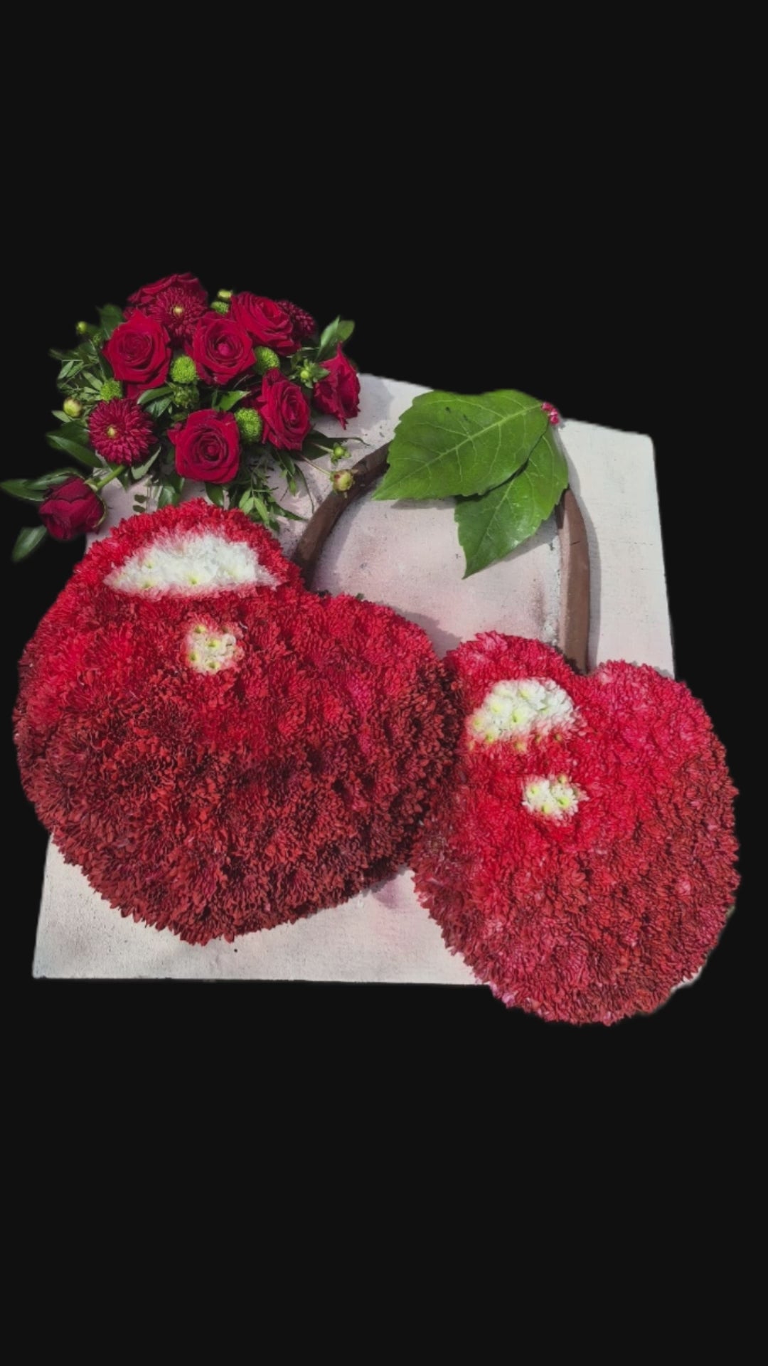 A FlowerLife florist creating a bespoke floral tribute of 2 cherries for a funeral